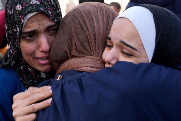 Palestinians mourn relatives killed in the Israeli bombardment of the Gaza Strip in front of the morgue in Deir al Balah, Sunday, Nov. 19, 2023. (AP Photo/Hatem Moussa)