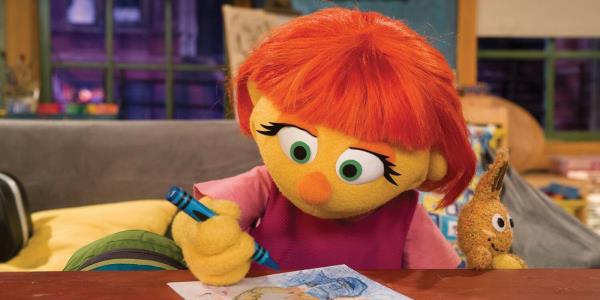 Julia, the first autistic puppet on Sesame Street, coloring a picture.